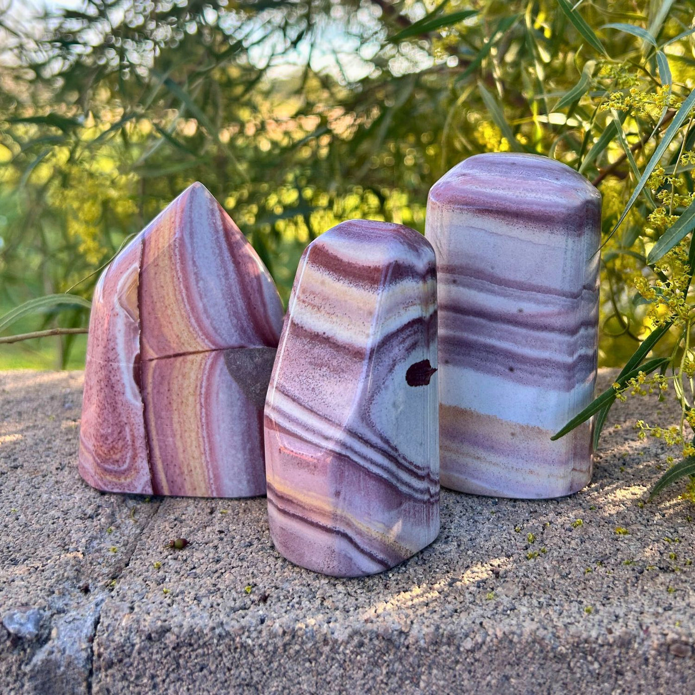 Collection of 3 Rainbow Rhyolite freeform crystals by Energy Muse to display the variance in shape, size, pattern and color.