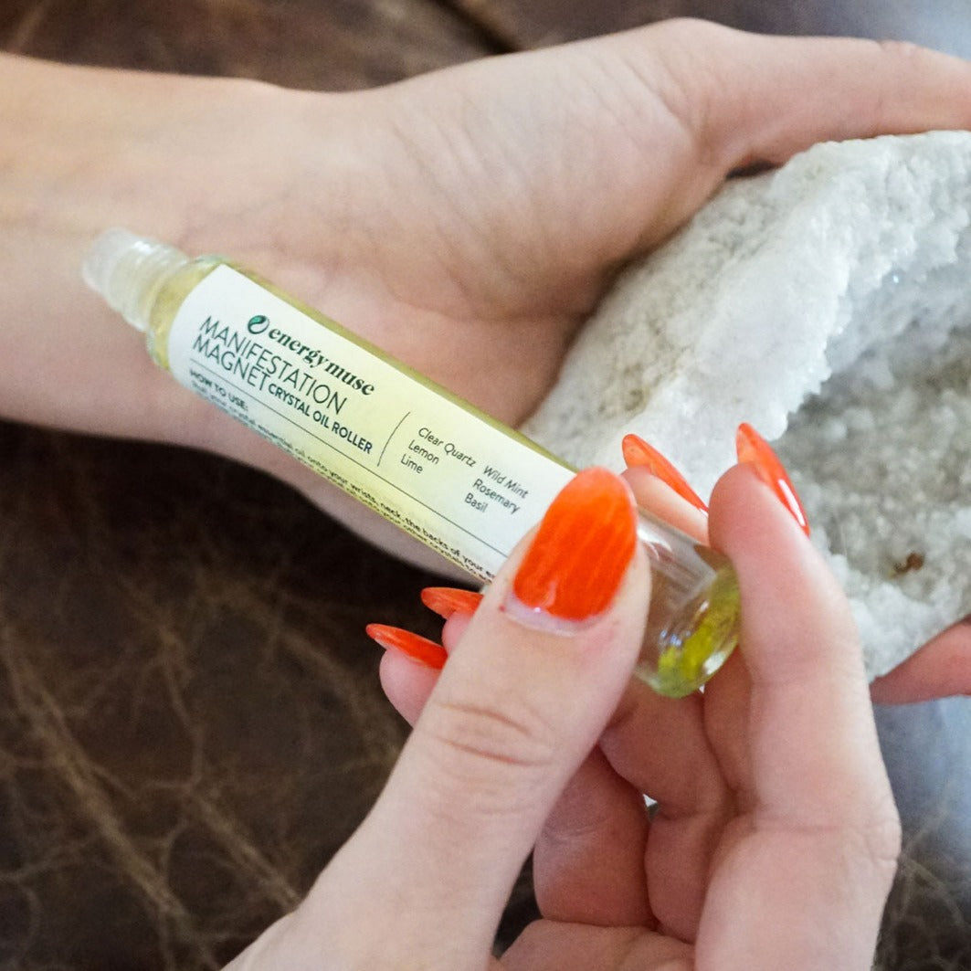 Woman's hand holding refreshing essential oil roller with genuine crystal chips by Energy Muse