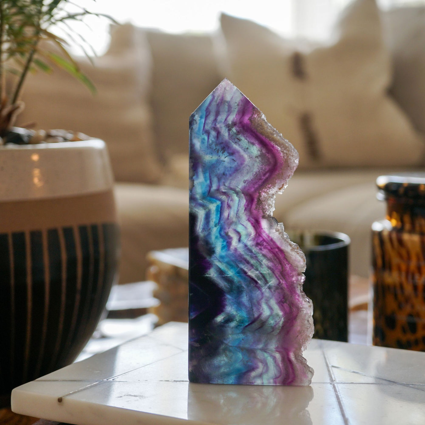 A crystal point on a desk beside a mug