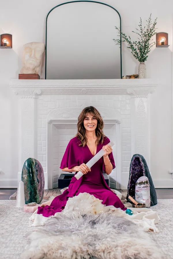 Heather Askinosie seated between two amethyst geodes