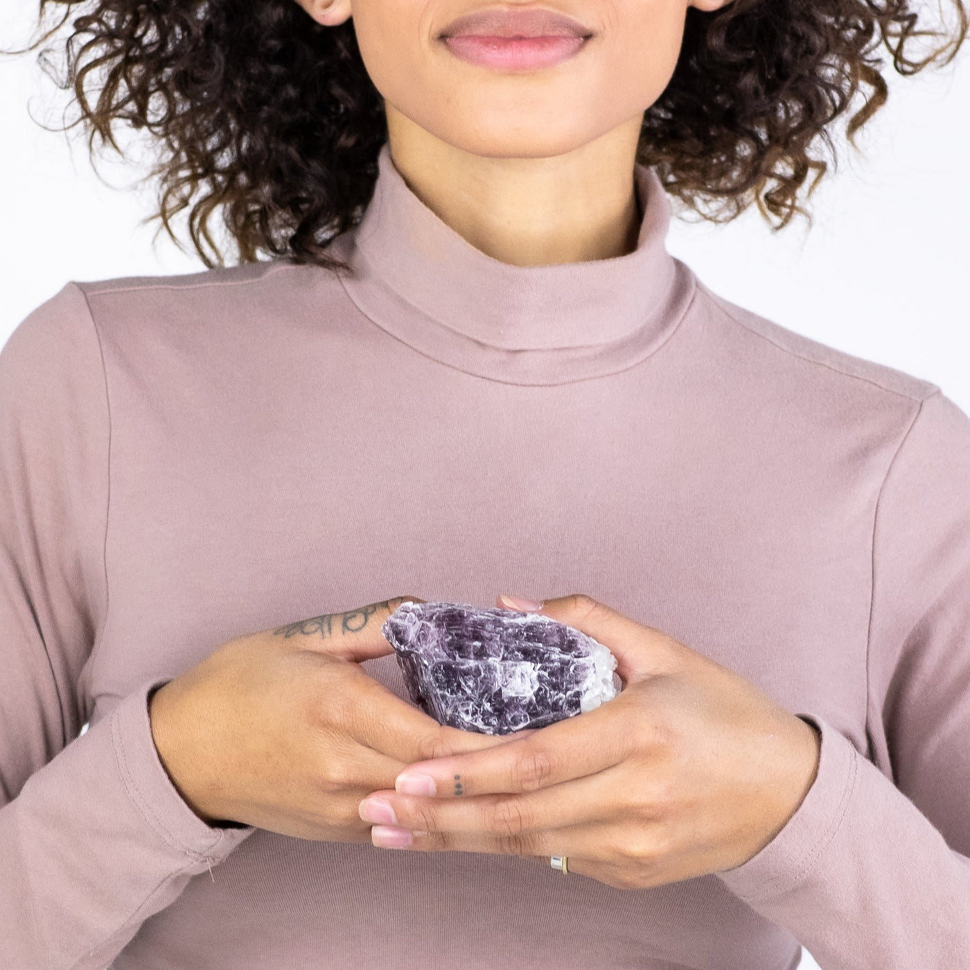 Biracial woman holding genuine Lepidolite crystal in both hands by Energy Muse