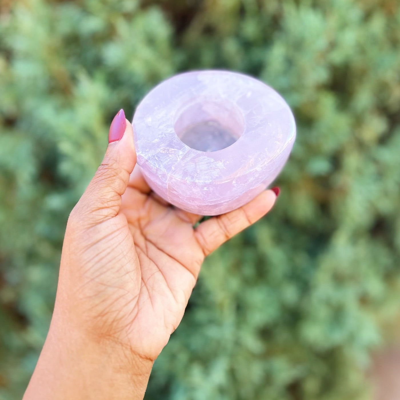 Woman holding up Rose Quartz tealight candle holder outdoors by Energy Muse