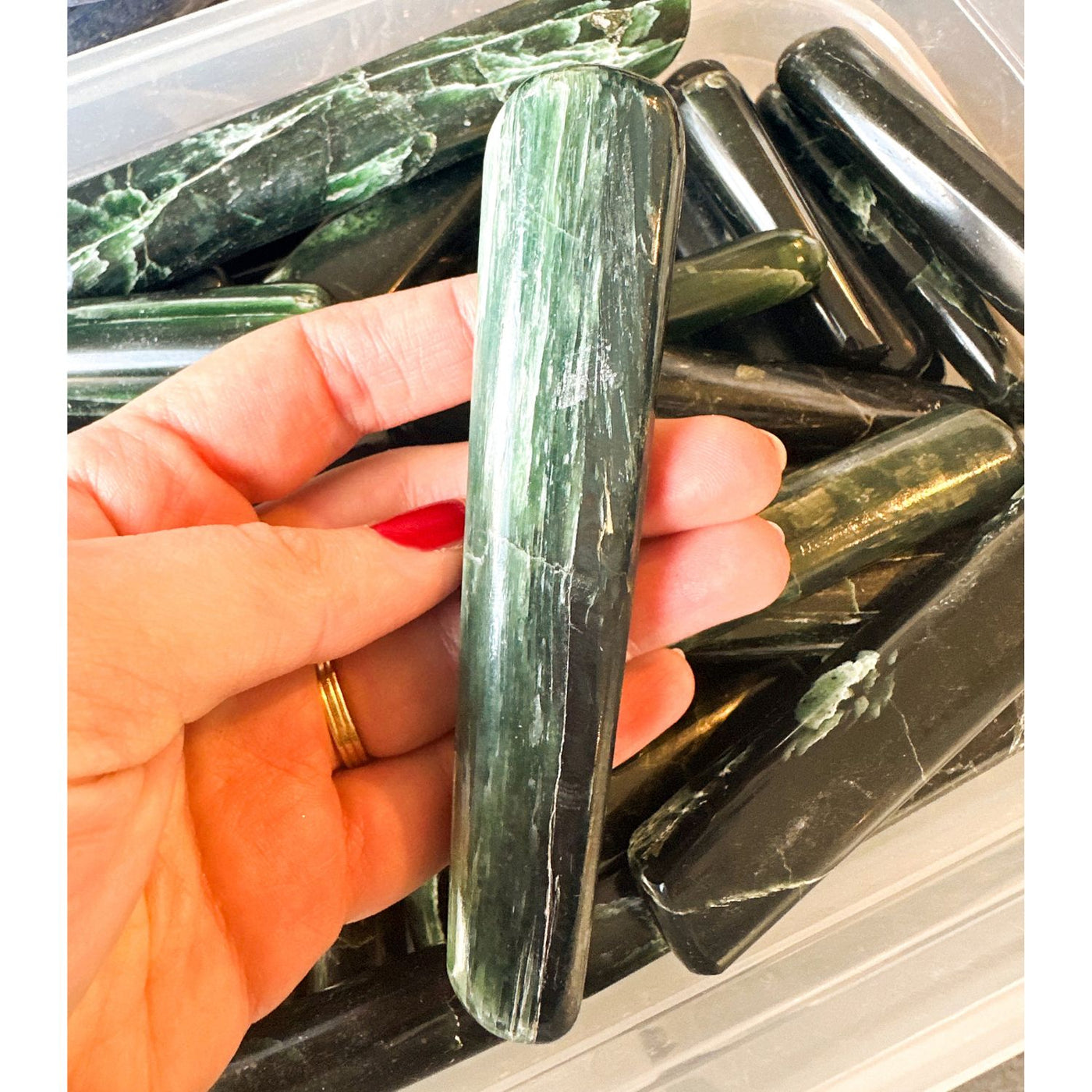 Woman holding medium size rare translucent a-grade green kyanite wand by Energy Muse