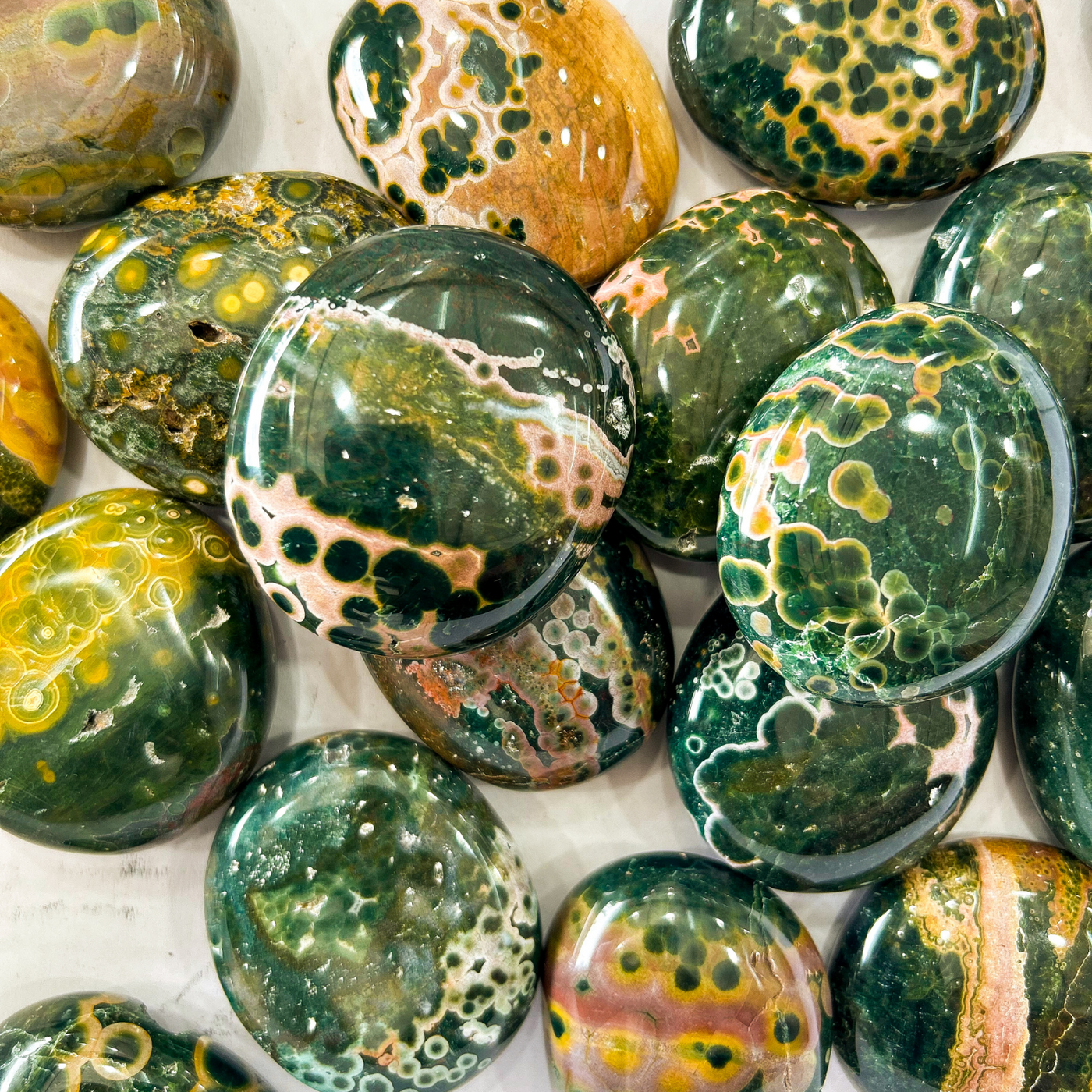 collection of several Kambamby Ocean Jasper touchstone at Tucson Gem Show displaying variety of colors, patterns and sizes by Energy Muse