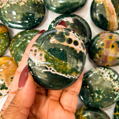 woman holding up Kambamby Ocean Jasper touchstone at Tucson Gem Show by Energy Muse