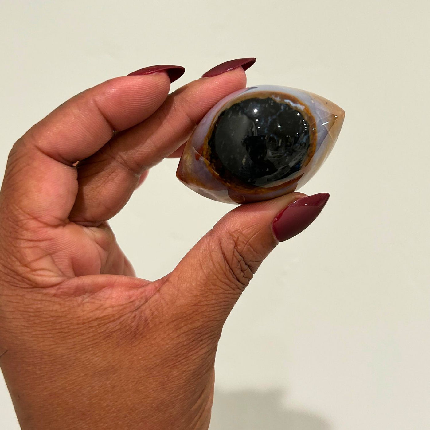 woman holding up genuine Shiva Eye Agate crystal by Energy Muse