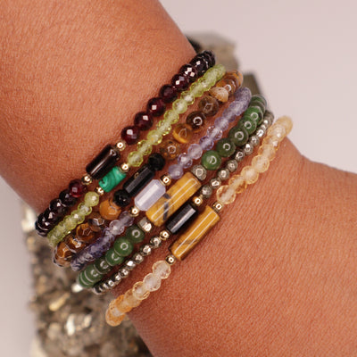 Black woman wearing all 7 wearable wealth crystal bracelets by Energy Muse