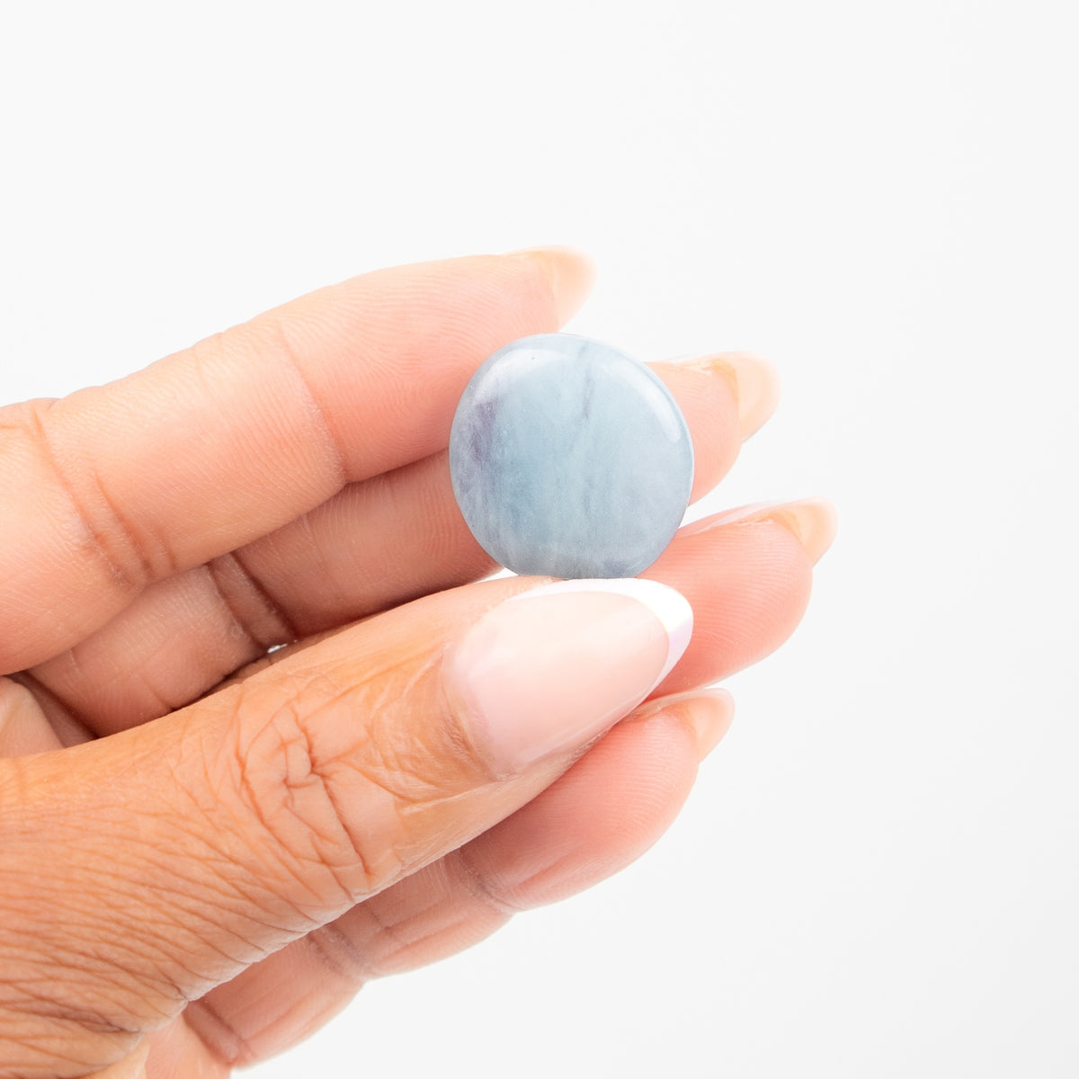woman holding up aquamarine tumbled stone - Energy Muse
