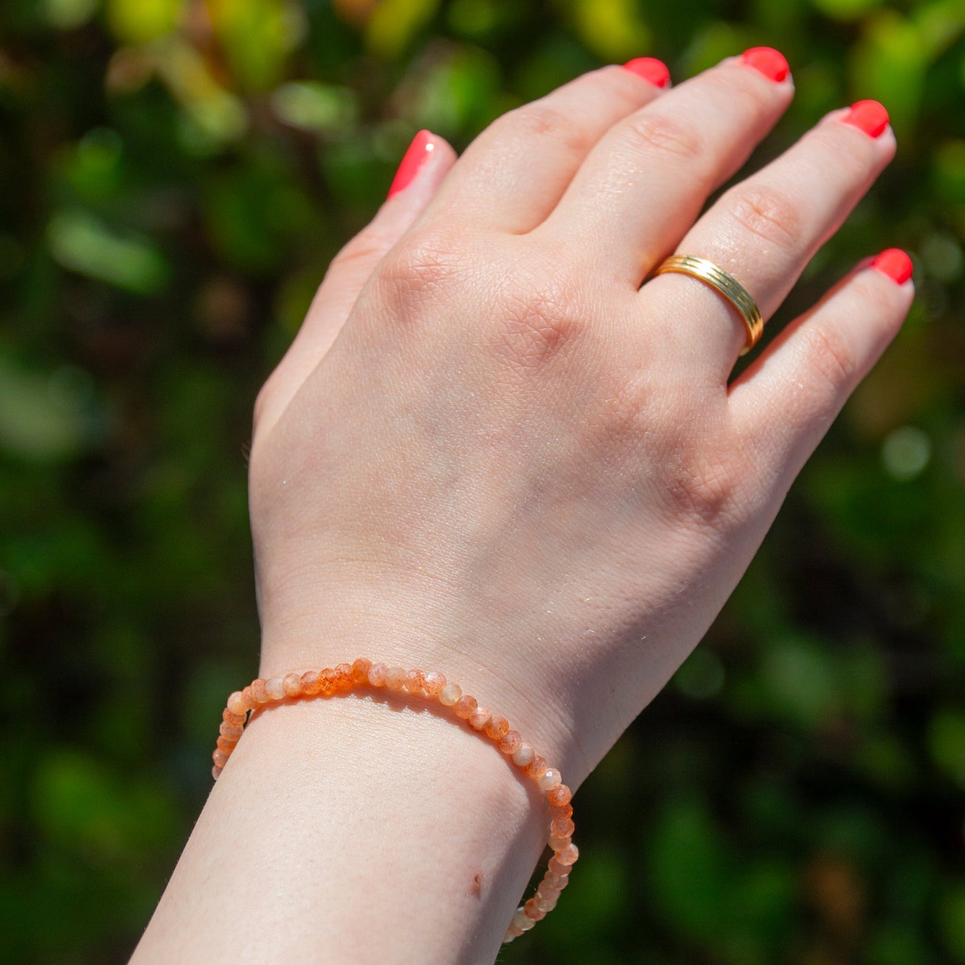 Woman wearing genuine Golden Sunstone mini gemstone dainty stretch bracelet on wrist by Energy Muse
