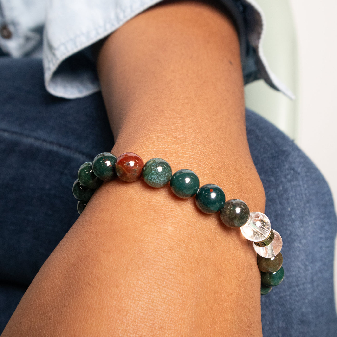 Detailed close-up view of genuine Bloodstone bracelet by Energy Muse as worn on a young biracial woman 