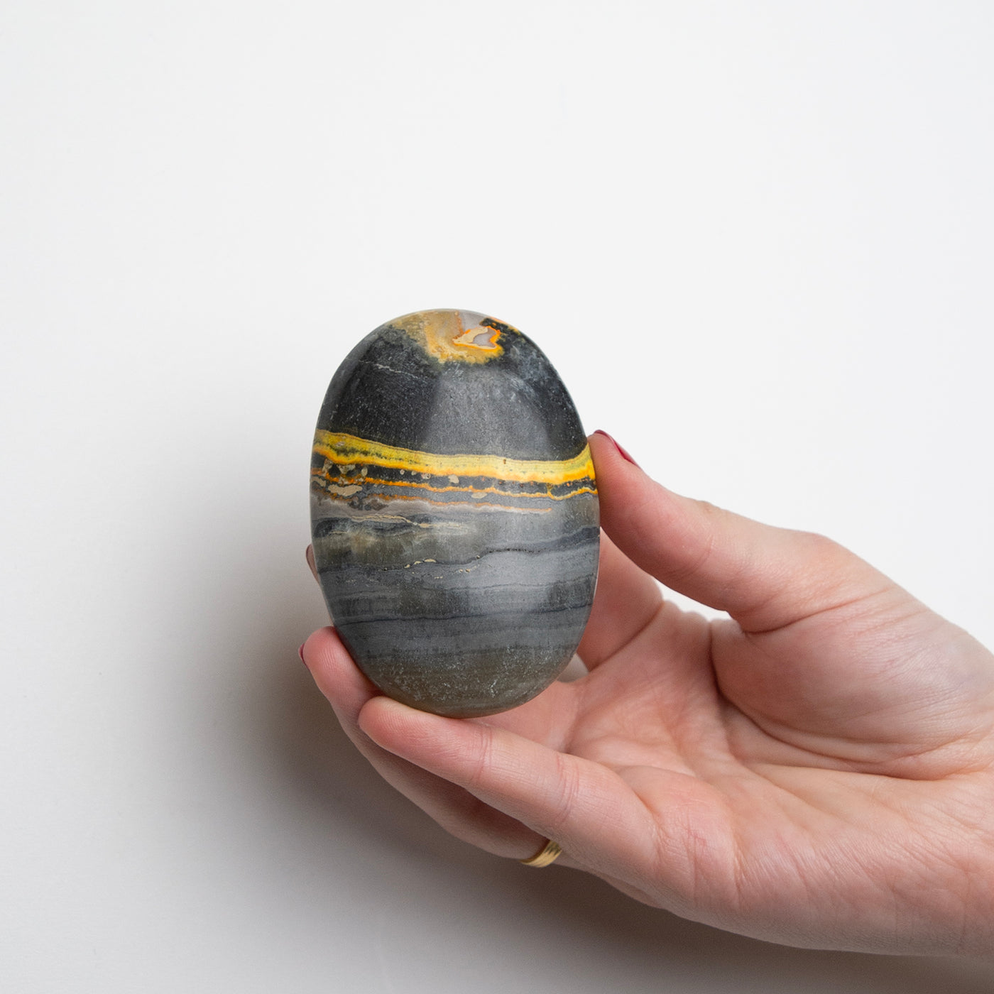 Woman holding Bumble Bee Jasper Touchstone by Energy Muse to show its large size. 
