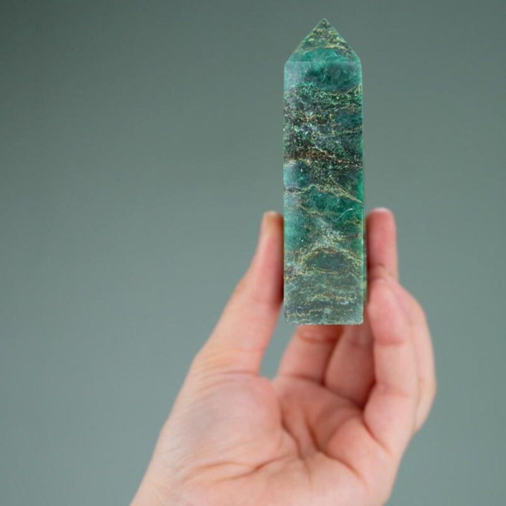 White woman holding genuine Emerald crystal Point by Energy Muse