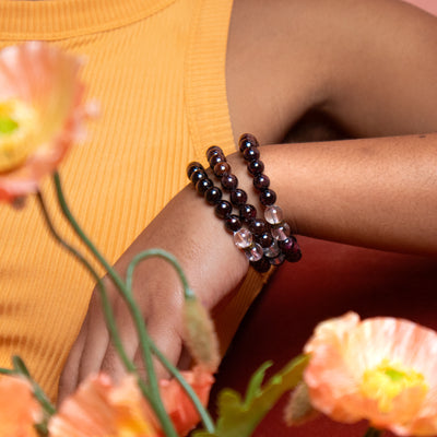 Close up of biracial woman wearing 3 Energy Muse garnet bracelets.