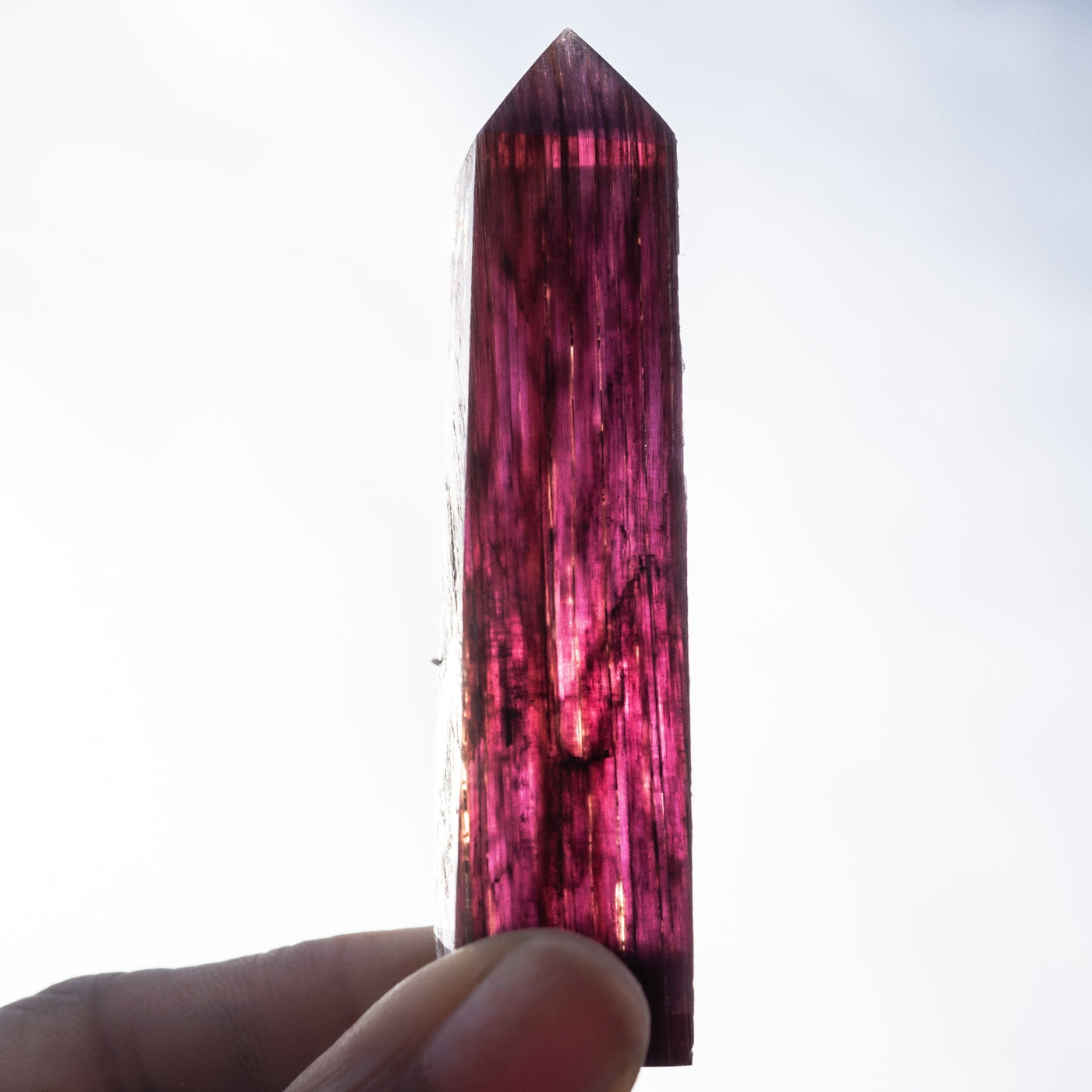 Close-up of woman holding a gem-grade Lepidolite Point with violet hues by Energy Muse