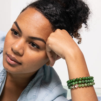 Closeup of young woman wearing 3 jade stretch bracelets by Energy Muse