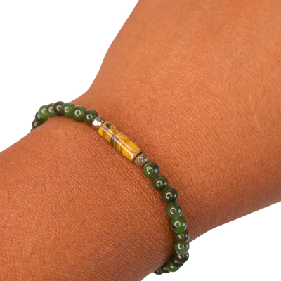 Close up view of Black woman's wrist wearing a Jade, Tiger's Eye and Pyrite Financial Advisor Bracelet by Energy Muse