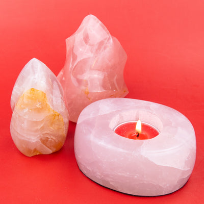 Stylized photo of Rose Quartz Tealight Candle Holder and 2 Rose Quartz Flame carvings by Energy Muse