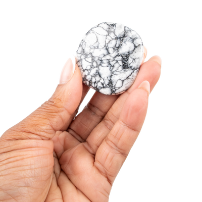 Woman holding up genuine Pinolith crystal pocket stone to show scale by Energy Muse