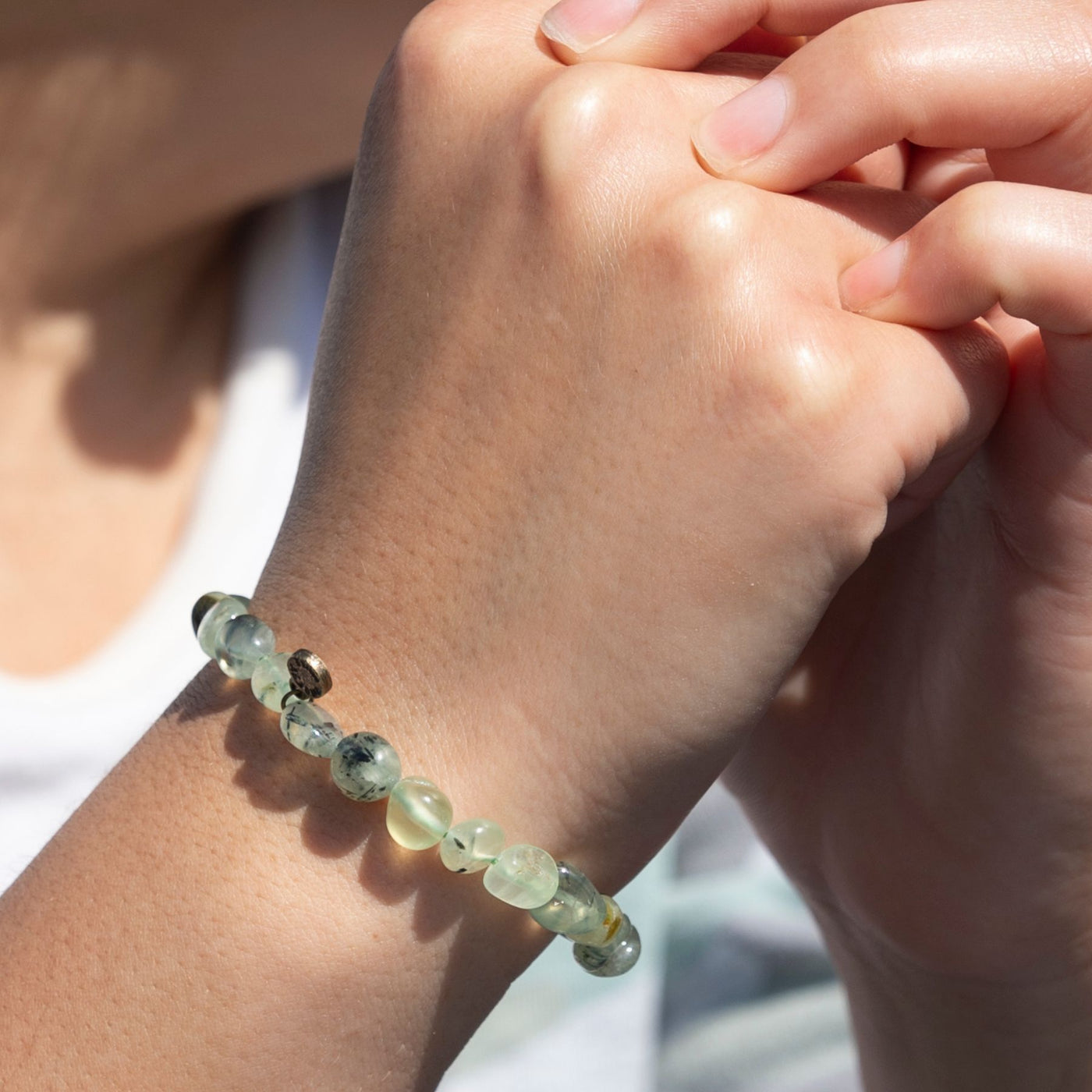 Woman wearing natural pebble shaped genuine green Prehnite crystal bead elastic bracelet by Energy Muse