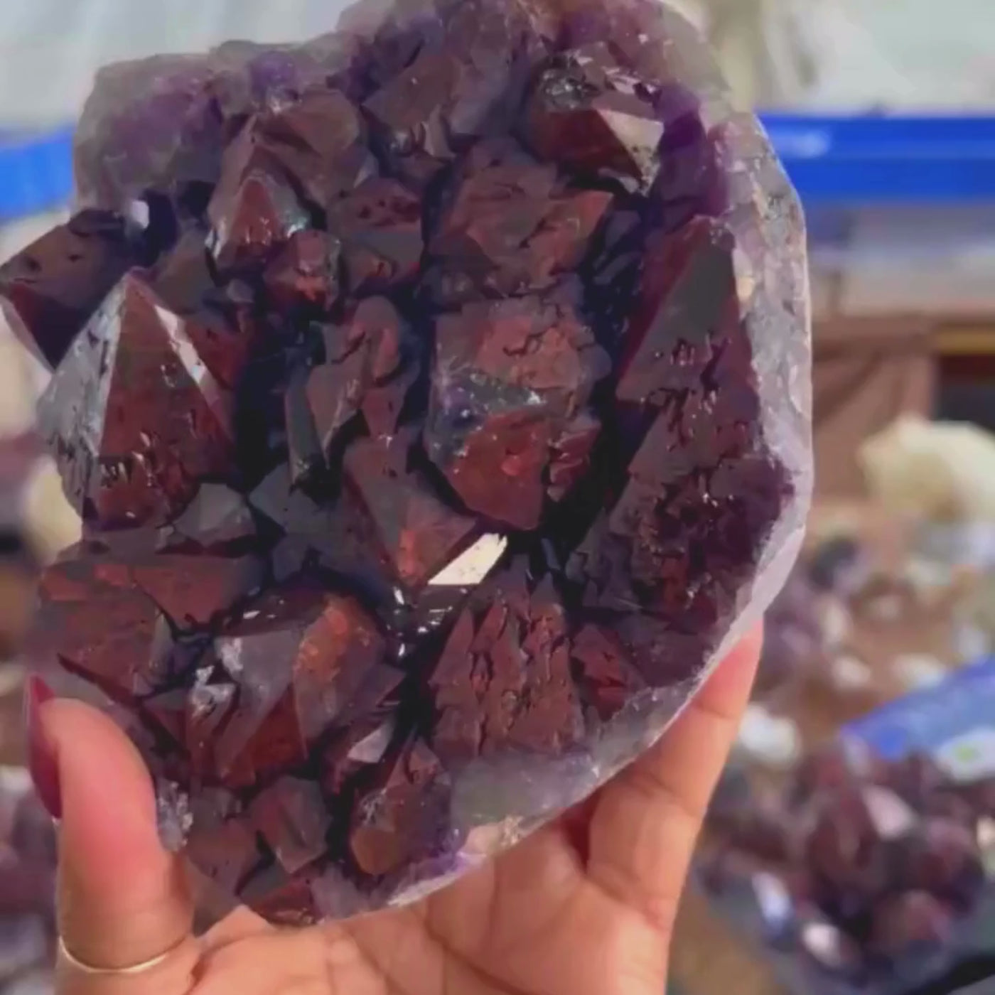 short video of a woman holding and and turning around an Alien Amethyst crystal to display different facets, colors, and patterns by Energy Muse