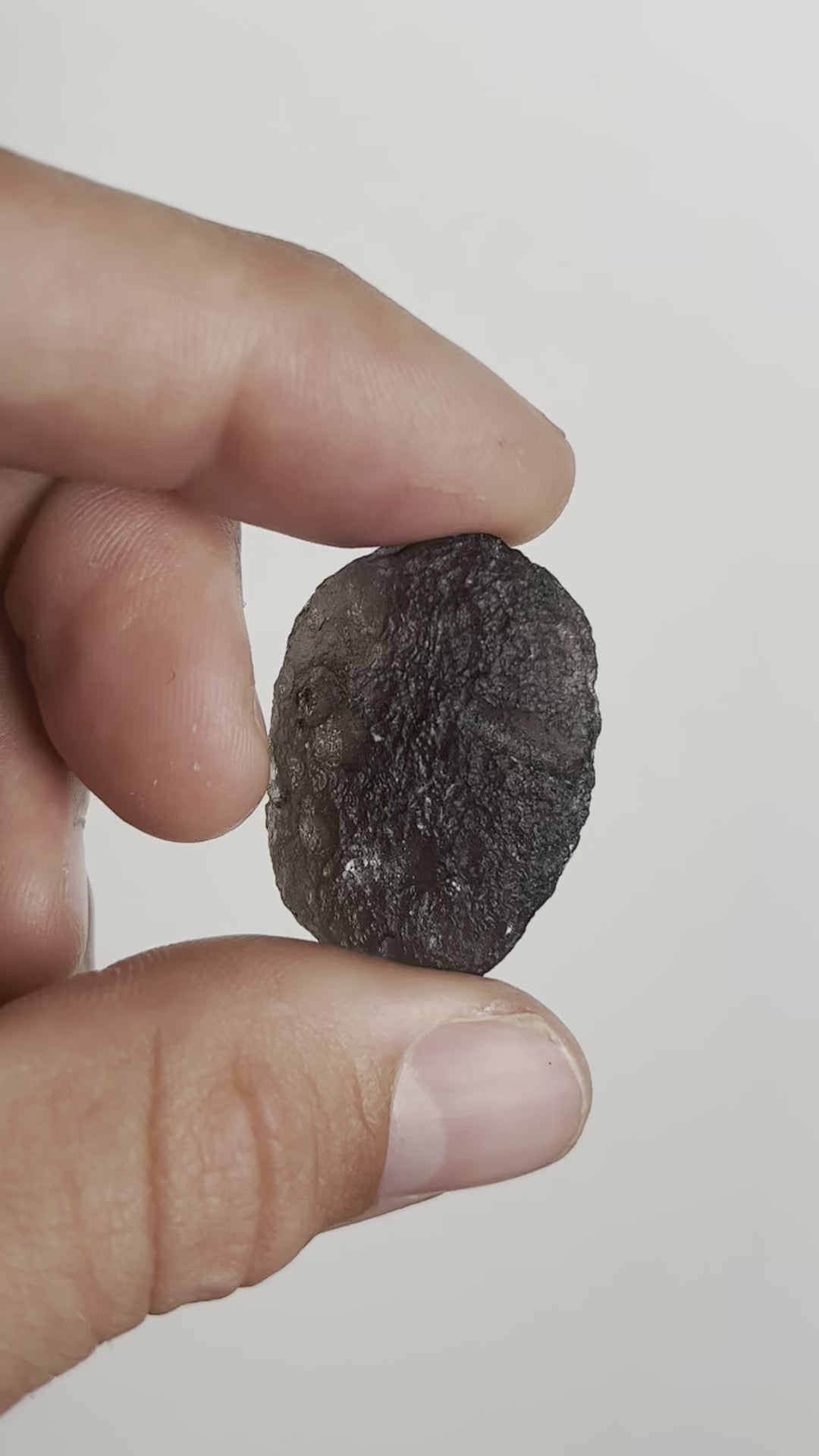 video of person holding raw tektite stone by Energy Muse