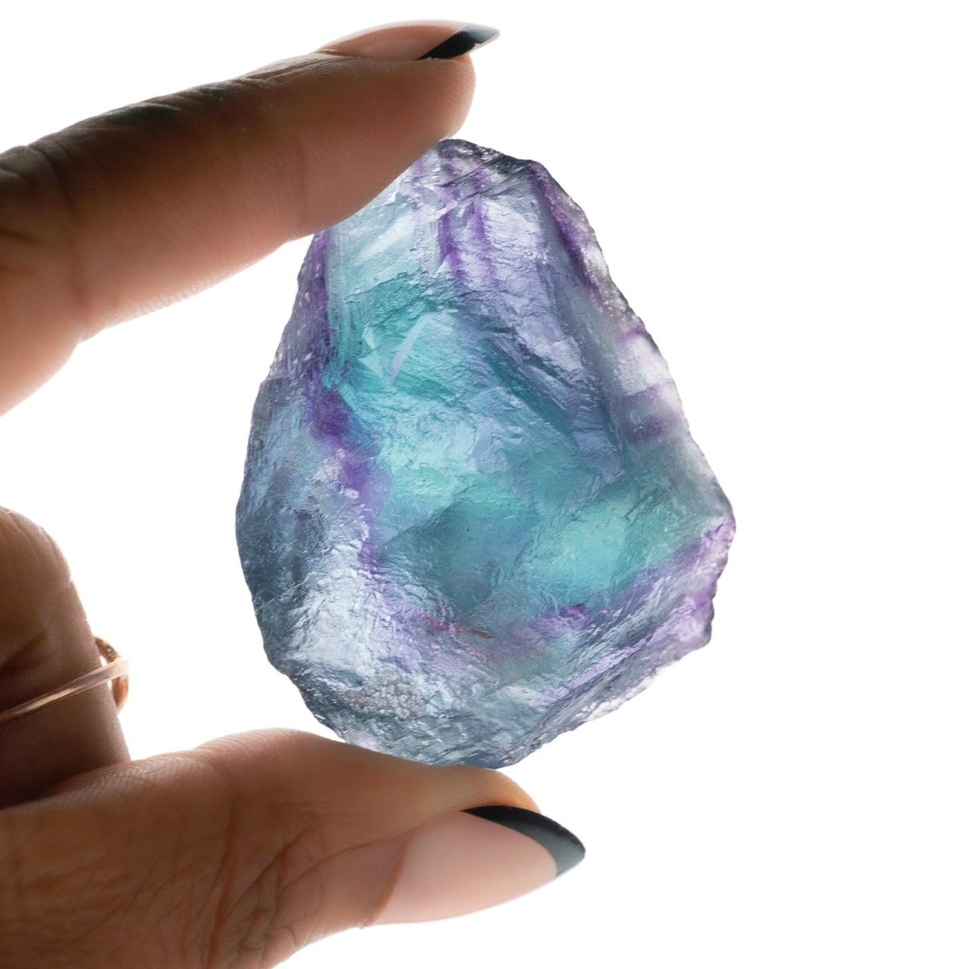 Close-up view of semi-opaque raw fluorite crystal held up to light by Energy Muse