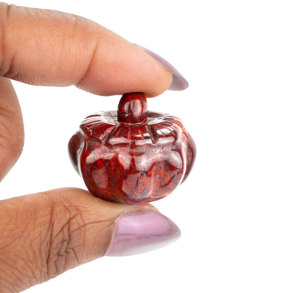 Woman holding genuine red jasper pumpkin carved crystal by Energy Muse