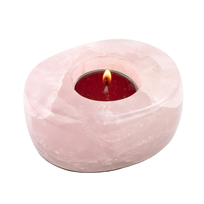 closeup of Rose Quartz tealight candle holder with burning tealight in the center by Energy Muse