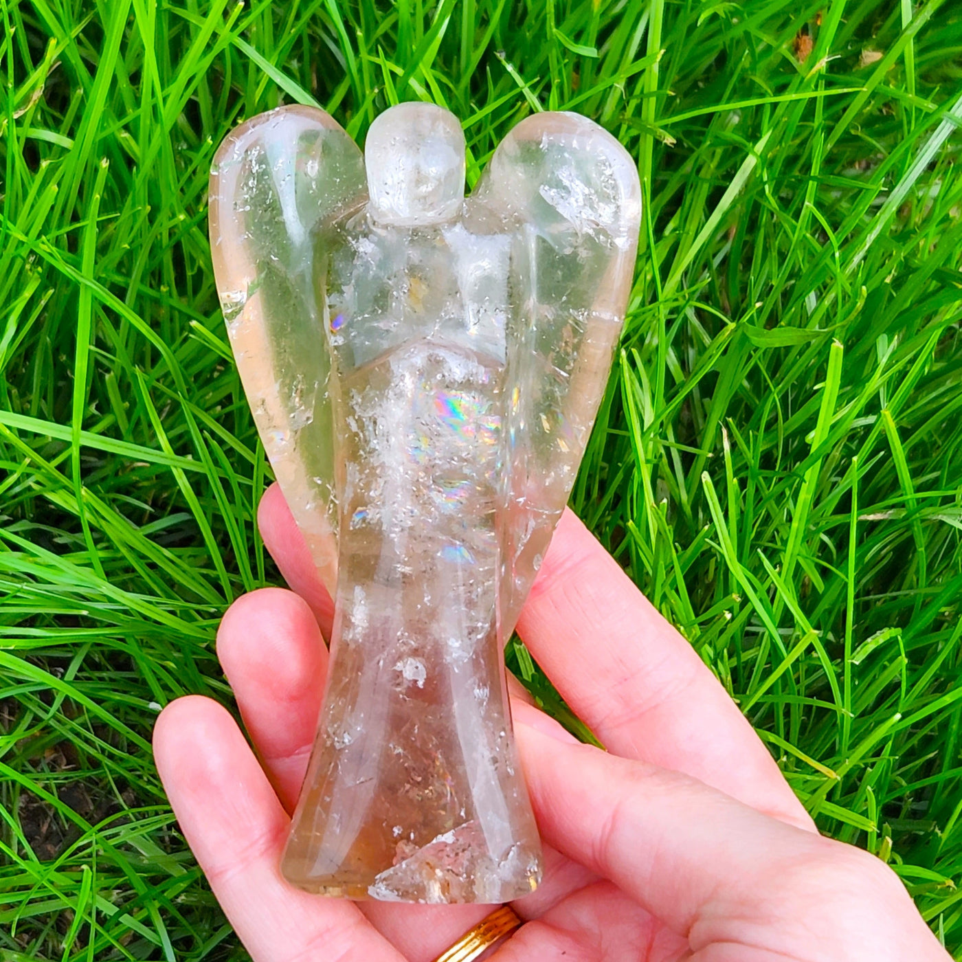 genuine Smoky Quartz angel carving shape by Energy Muse shown outside in natural light displaying the natural prismatic rainbows within