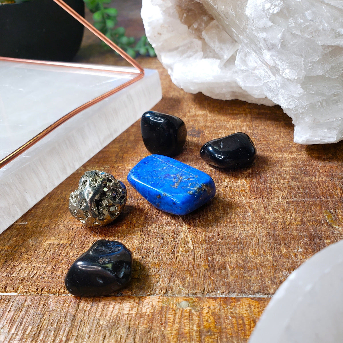 Protection Stones Bag by Energy Muse on wooden table with Copper Pyramid and Selenite Charging Plate