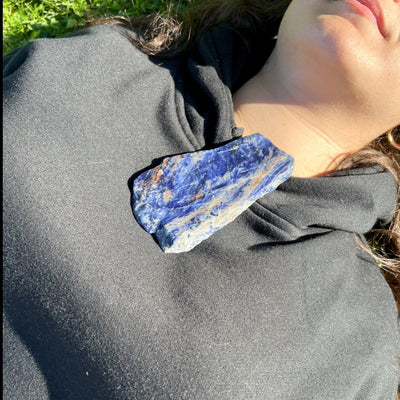 Woman laying on grass with irregular Sodalite slab crystal by Energy Muse