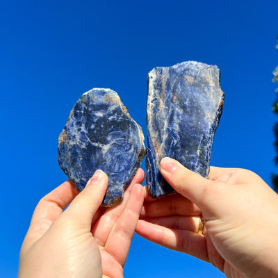 Woman holding up 2 irregular Sodalite slab crystals by Energy Muse