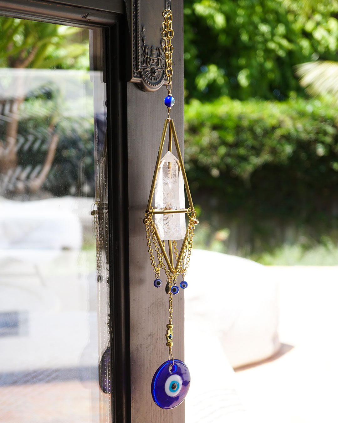 close up of gold crystal chandelier with natural clear quartz point, evil eye charms, clear crystal faceted prism ball and loop by Energy Muse