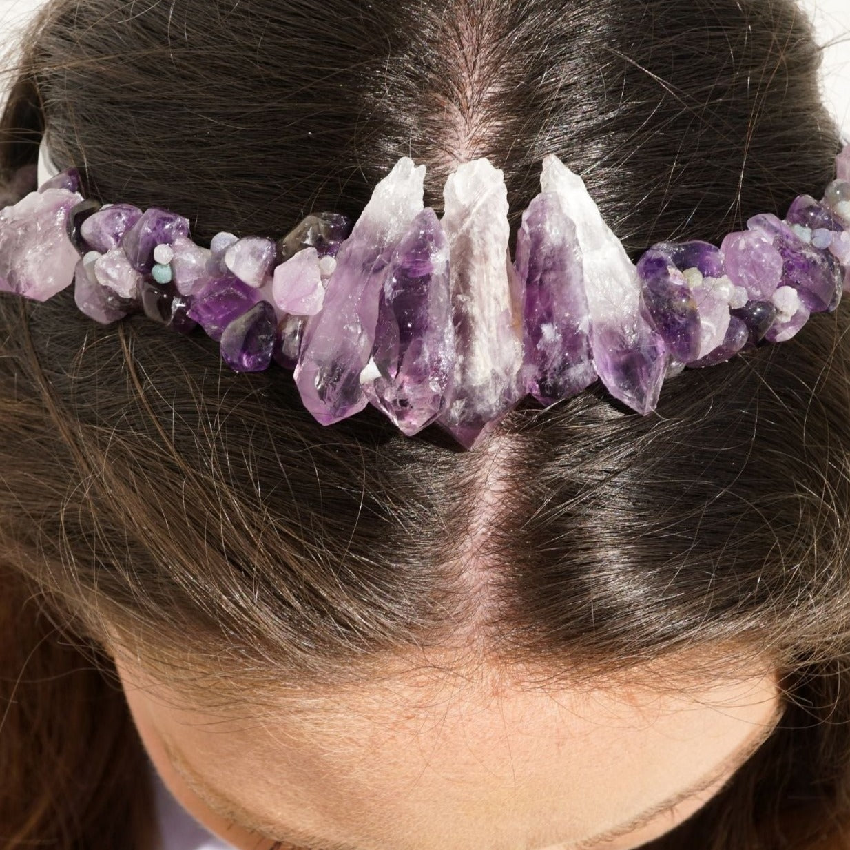 View from above of a brunette woman wearing frontal view of genuine Amethyst raw point crown tiara headband by Energy Muse