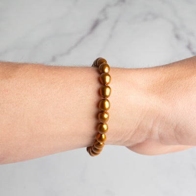 Bronze Gold Oval Pearl Bracelet on person's wrist by Energy Muse