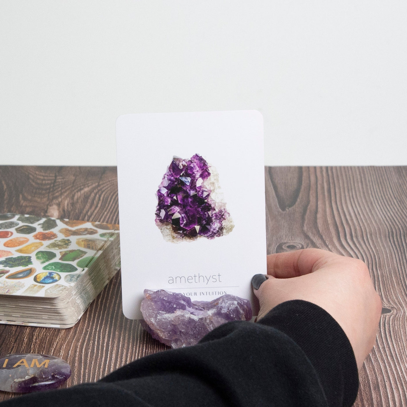 Woman placing Crystal Card Deck card inside raw Amethyst card holder by Energy Muse
