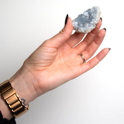 woman holding differently shaped blue celestite crystal cluster geode by Energy Muse