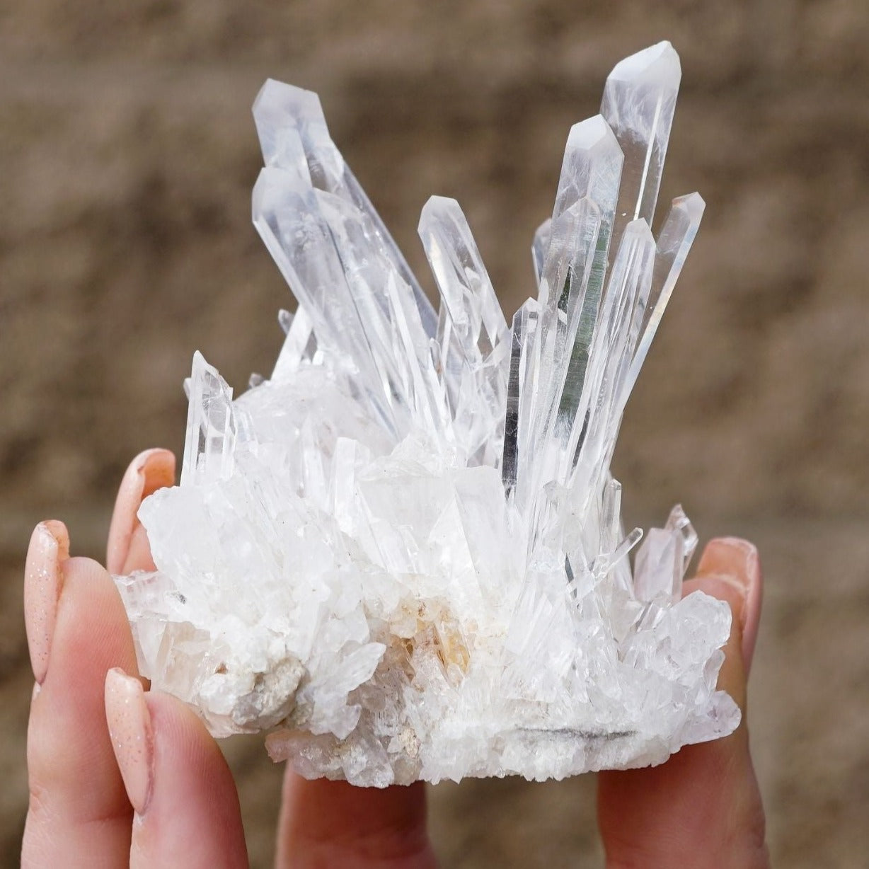 White woman holding genuine Colombian Clear Quartz cluster by Energy Muse