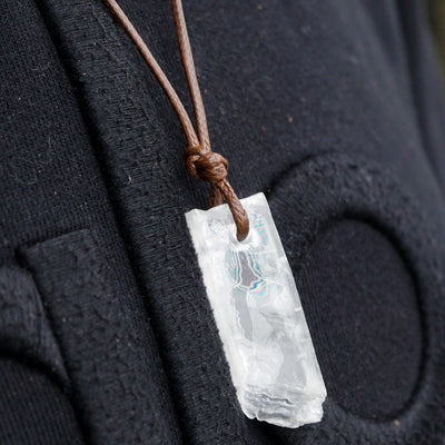 45 degree angle view of new Selenite energy healing necklace by Energy Muse that displays the natural prismatic rainbow effects within 