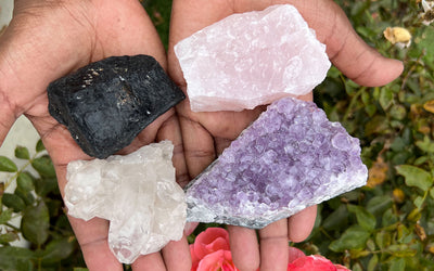 Woman holding Black Tourmaline, Clear Quartz, Amethyst, and Rose Quartz crystals from the Essential Crystals for Wellness Kit by Energy Muse