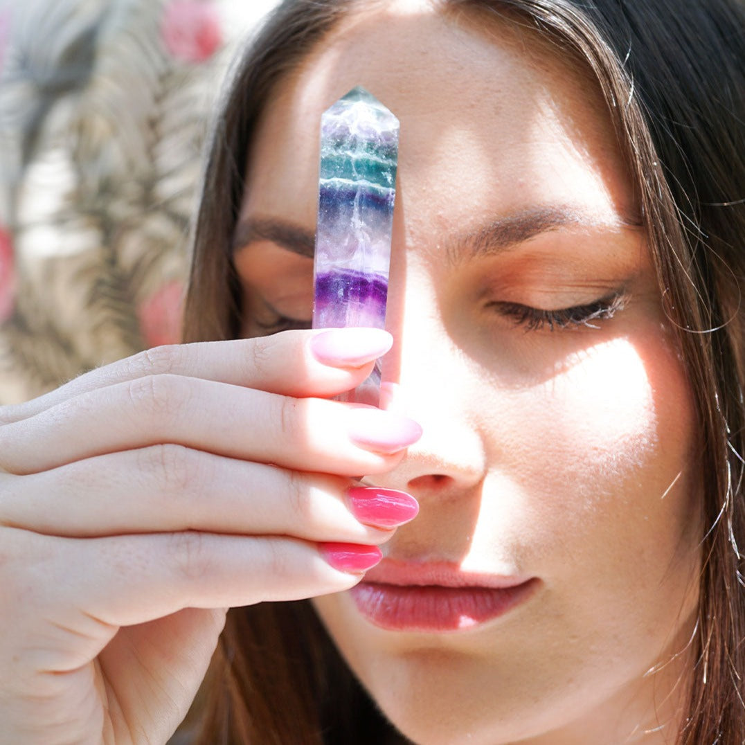 young woman holding genuine Fluorite double terminated crystal wand point by Energy Muse
