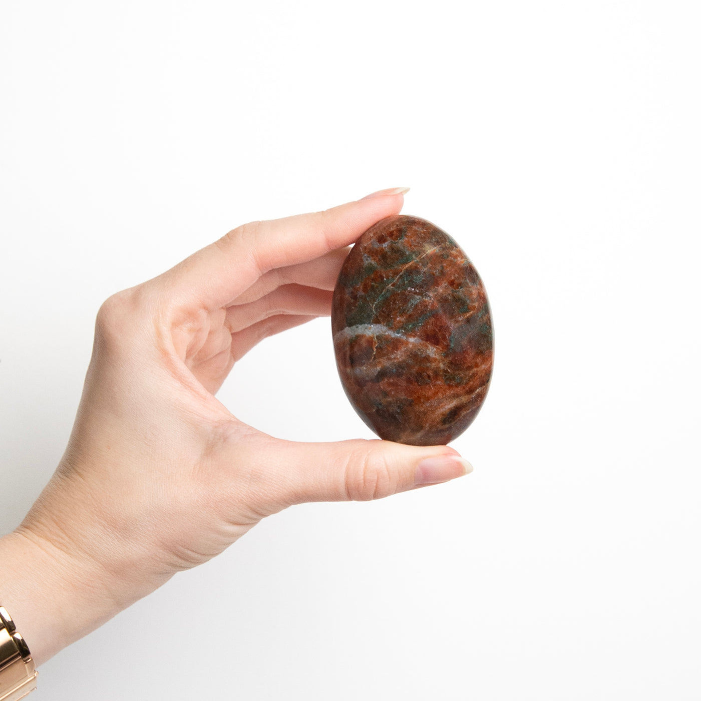 woman holding Hessonite Garnet Touchstone in one hand to show size by Energy Muse