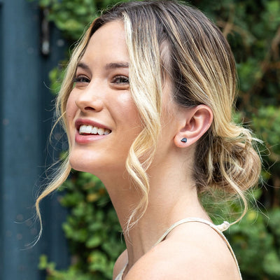 Smiling young blonde woman wearing genuine raw Black Tourmaline crystal earrings from Energy Muse. 