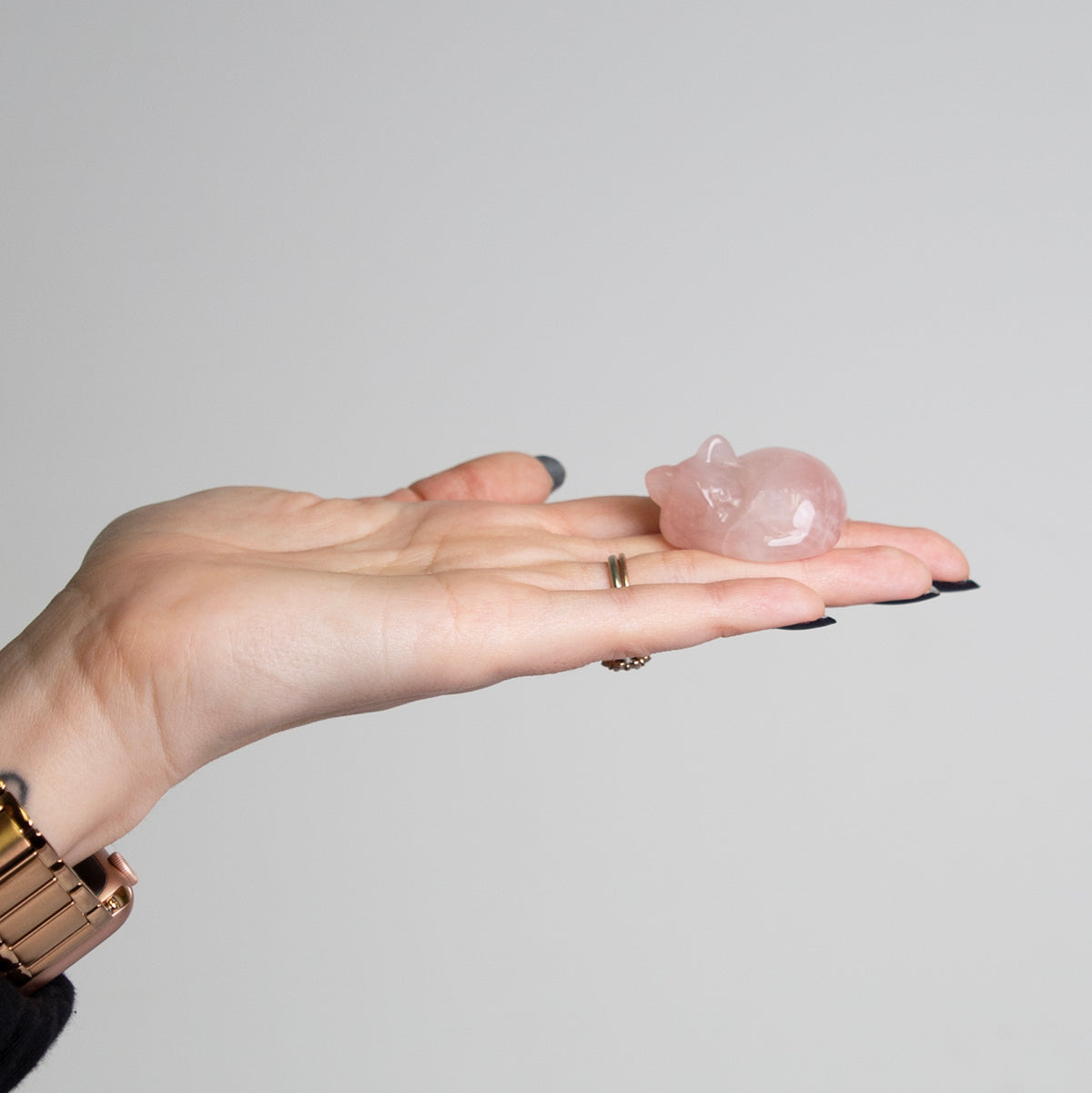 Woman holding rose quartz curled cat crystal carving by Energy Muse