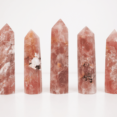 Image of 5 unique rose quartz points by Energy Muse showing their variety, different sizes, patterns, colorations, and heights.