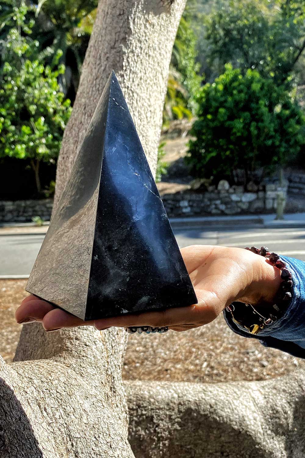extra tall genuine shungite pyramid held in person's hand outside by Energy Muse