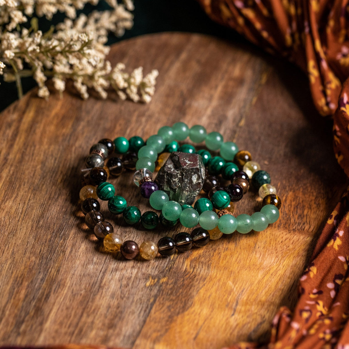 All 3 natural crystal bracelets featured in Wealth Bracelet Set on wooden display by Energy Muse